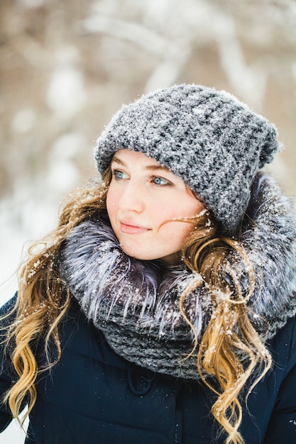 ヨーロッパ風の女の子が公園、森、冬、雪の中を歩き、暖かい服を着て、帽子、ジャケット、スカーフ、残り、ハイキング