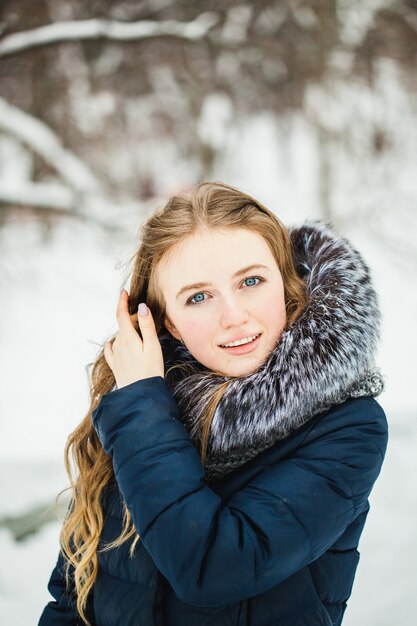 A girl of European appearance walks in the Park or forest in winter