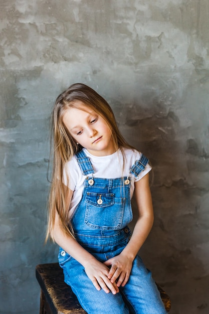 Photo girl of european appearance with light long hair sadness on her face, thoughtfulness, childhood, school, parents, grades