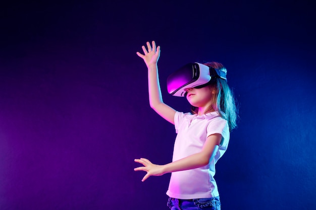 VRヘッドセットゲームを経験している女の子。バーチャルリアリティにゲームガジェットを使用する子供。