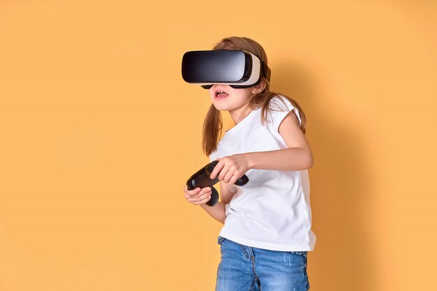 VRヘッドセットとジョイスティックゲームを経験している少女。彼女の顔に驚いた感情。バーチャルリアリティにゲームガジェットを使用する子供。