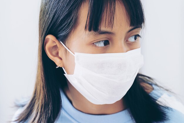 Girl under face mask covering mouth and nose. Corona Virus or COVID-19 concept.