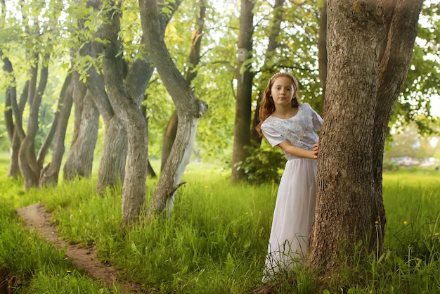 Photo girl in fairy tale park with tree in spring