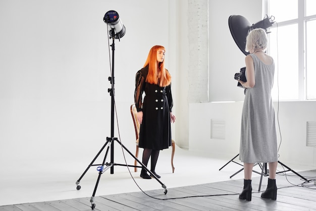 La modella e il fotografo della ragazza sono in studio su sfondo bianco