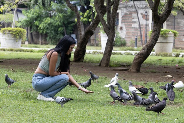 Girl feeding pigeons in the park