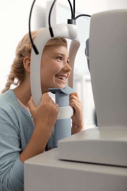 Girl feeling joyful. Beautiful teenage girl feeling joyful while having ophthalmologist consultation