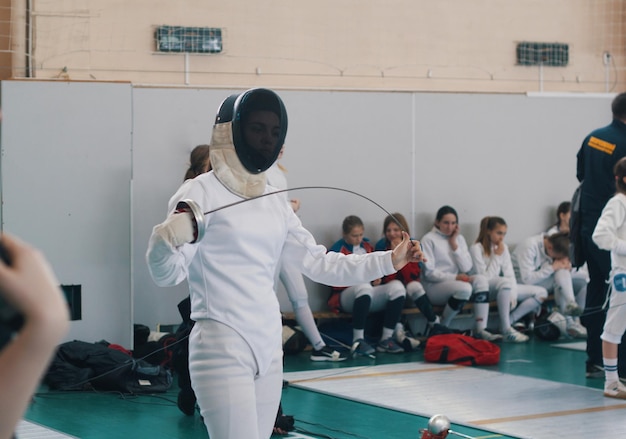 Photo a girl fencer having fencing duel on tournament a girl bending a saber