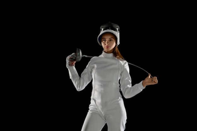 girl in fencing costume with sword in hand isolated on black