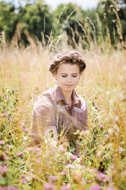 The girl in the field collects a bouquet of clover