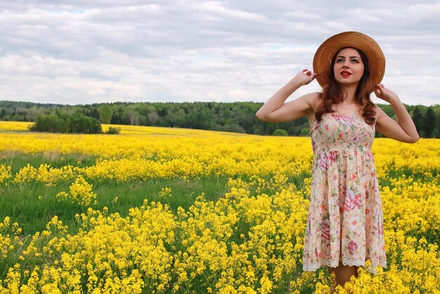 Girl in a field of flowers with basket and a hat