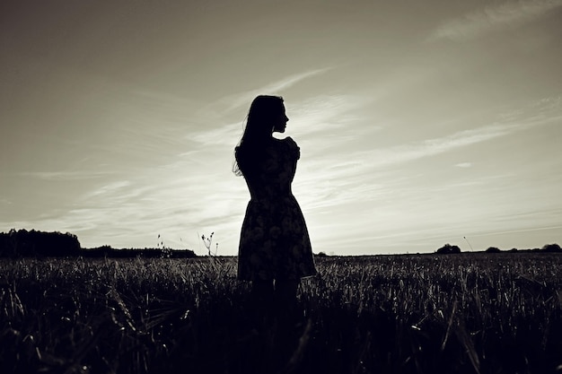 Girl in the field on sky background sunset