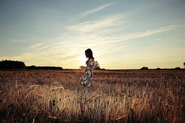 Girl in the field on sky background sunset