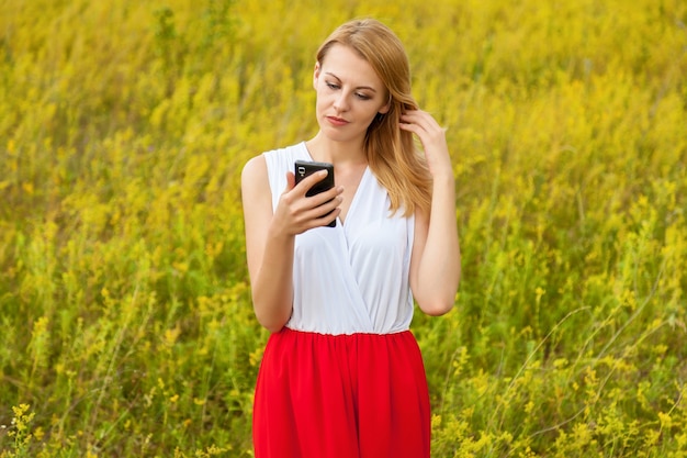 Girl in the field with a black phone. Girl in the field with phone.