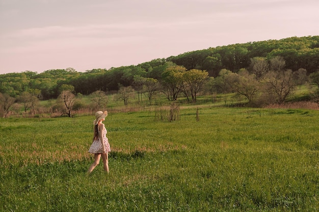 A girl in a field with a hat on