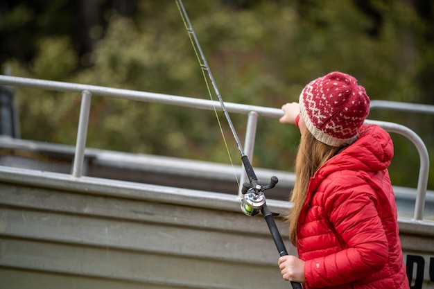 Girl fishing in a boat in summer in australia