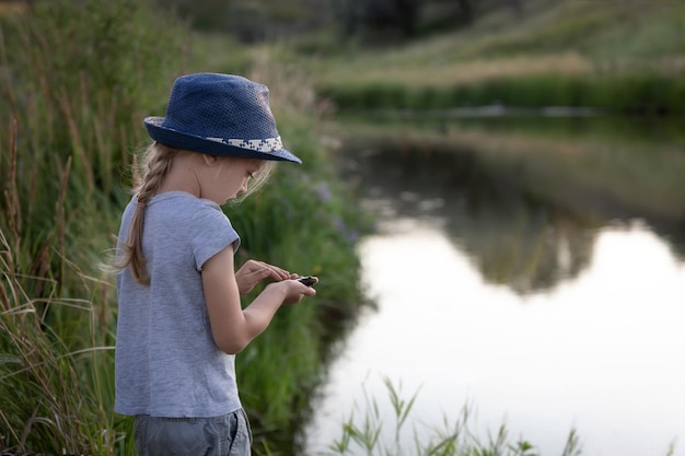 A girl on a fishing trip caught a fish and examines it