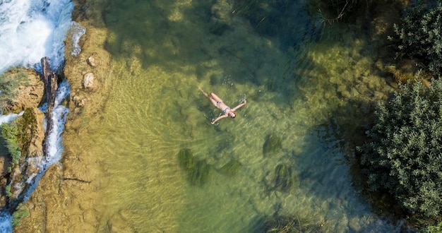 Photo girl floating on the waterfall on the mreznica river croatia