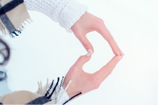 The girl folded her fingers in the shape of a heart on the backg