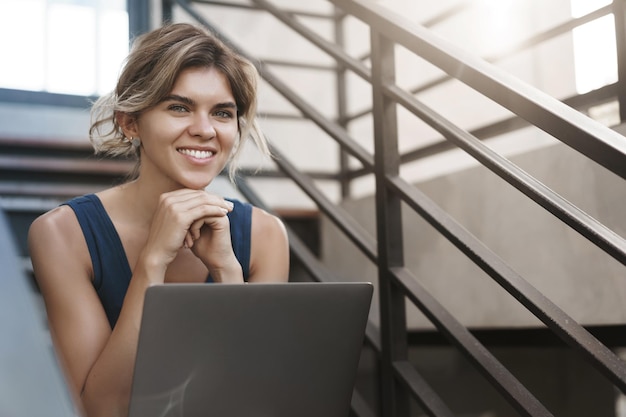 Girl found wifi spot near campus sit alone outdoor stairs hold laptop knees smiling delighted work outside office fresh air researching studying before exams digital nomad collect information