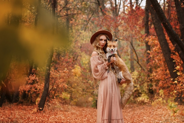 Girl and fox in the woods in autumn