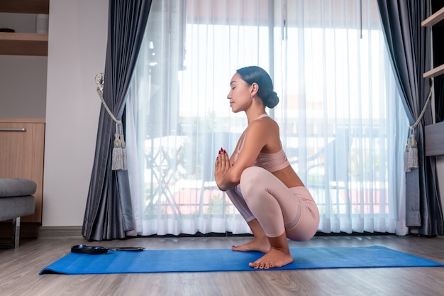 Una ragazza di razza mista, che posa in piedi in una posa di rana e gode di stretching