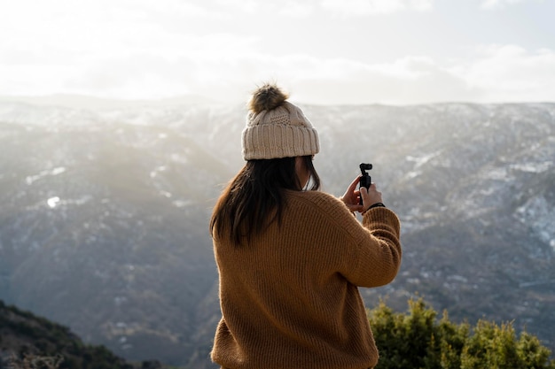 girl from behind taking video with device