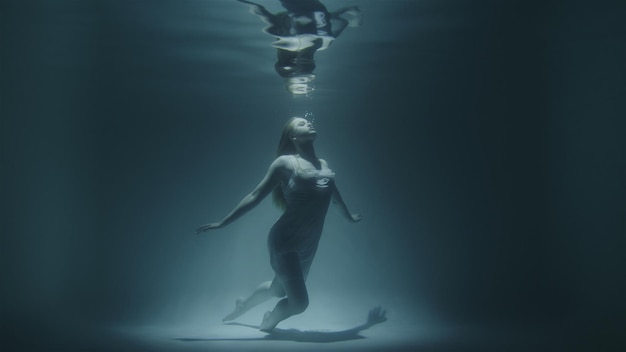 Girl froze under water at the bottom looking up