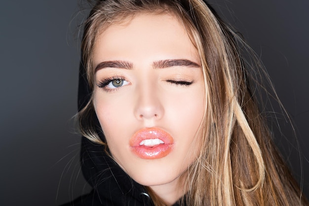 Girl funny face close up woman winking beauty fashion portrait smiling young woman wink up