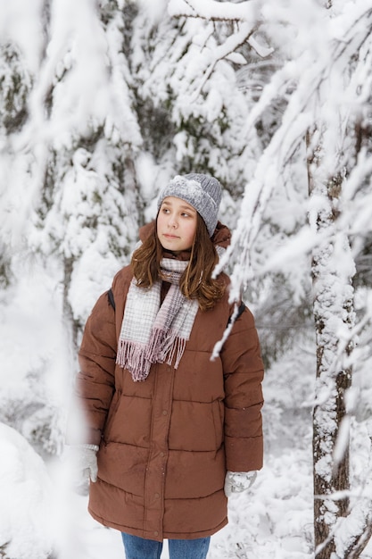 雪に覆われた森の毛皮のコートの女の子