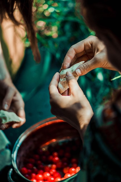 Foto la ragazza in giardino fa gli gnocchi con le ciliegie 4