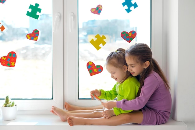 Girl gave her little sister a heartshaped card with puzzles for autism Day