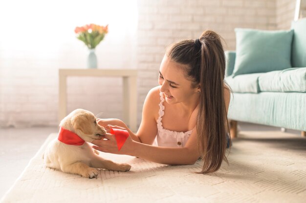 Girl gently plays with a puppy on the floor