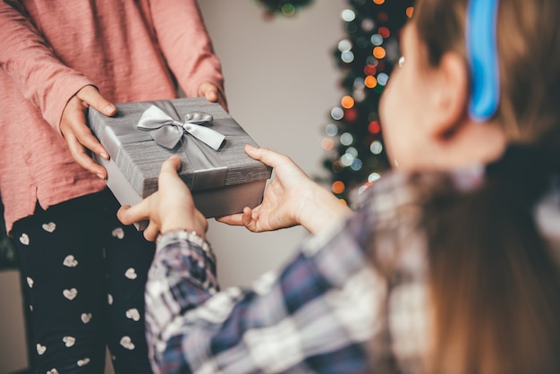 彼女の友人にクリスマスプレゼントを与える少女