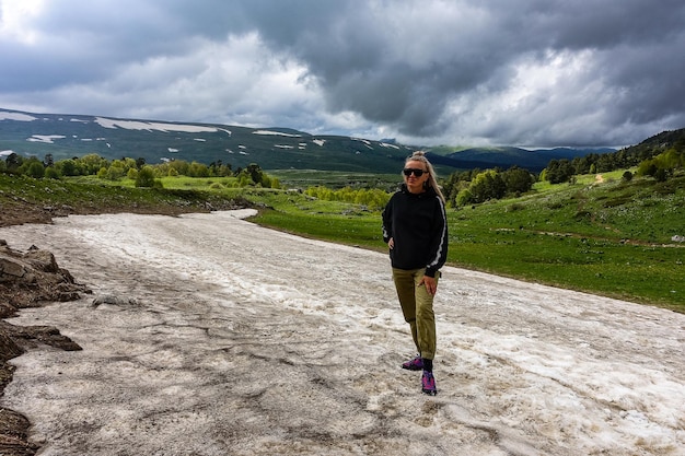 Una ragazza su un ghiacciaio sull'altopiano lagonaki neve ad adygea russia 2021