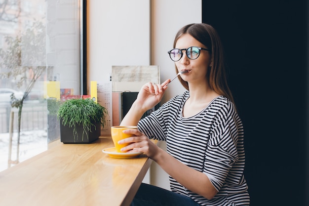 Girl in glasses drinking coffee 