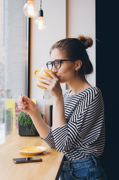 Girl in glasses drinking coffee 