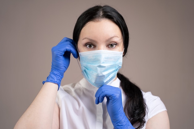 Girl in gloves putting on a mask