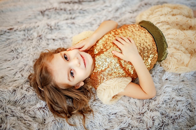 Girl in golden dress on fur