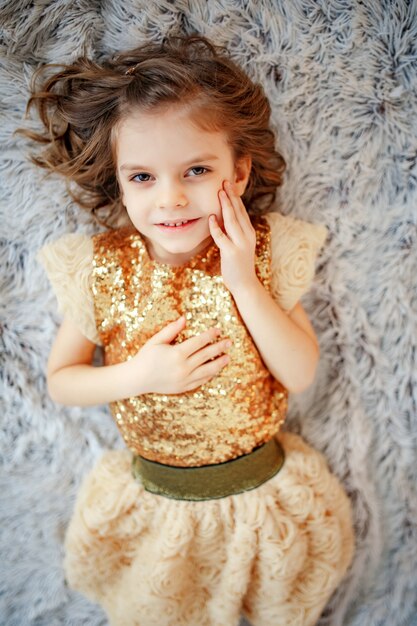 Girl in golden dress on fur