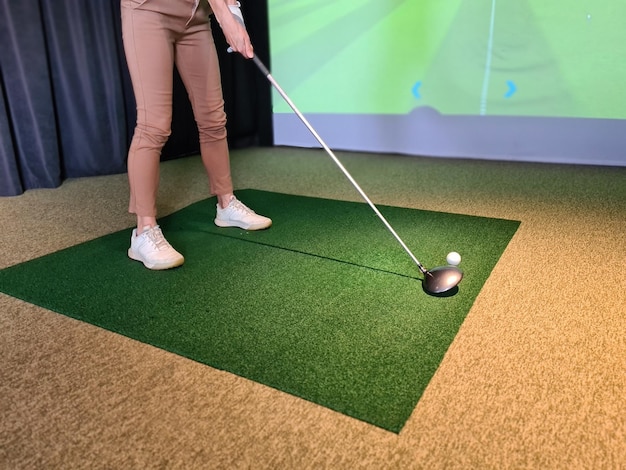 Photo girl golf player plays golf indoors closeup