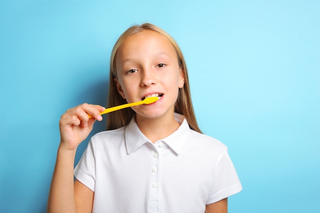 Girl in a good mood is brushing her teeth