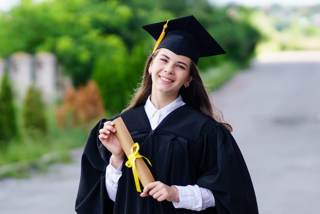 Girl in gown and cap holding a diploma