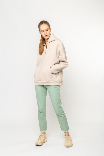 Girl in green cargo pants and beige hoodie isolated on white