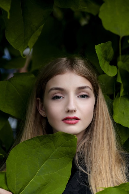 Girl in green leaves enjoying nature