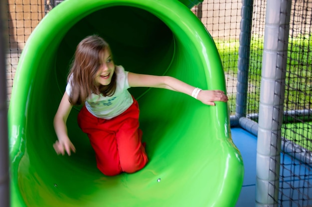 Foto una ragazza con una maglietta verde è su uno scivolo verde.