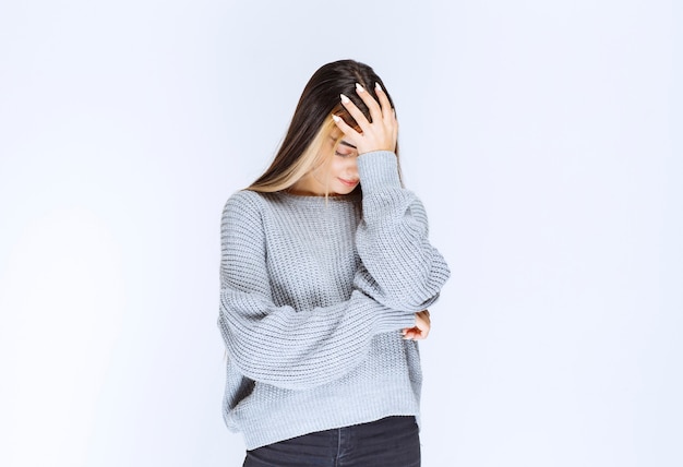 Girl in a grey shirt looks terrified and scared.