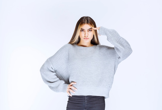 Foto la ragazza in camicia grigia sembra premurosa.