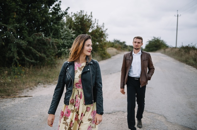 A girl and a guy are walking in the nature.