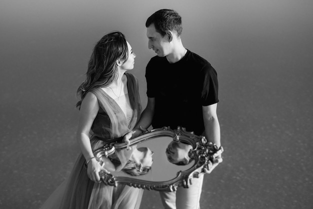 Girl and a guy on the shore of a pink salt lake at sunset