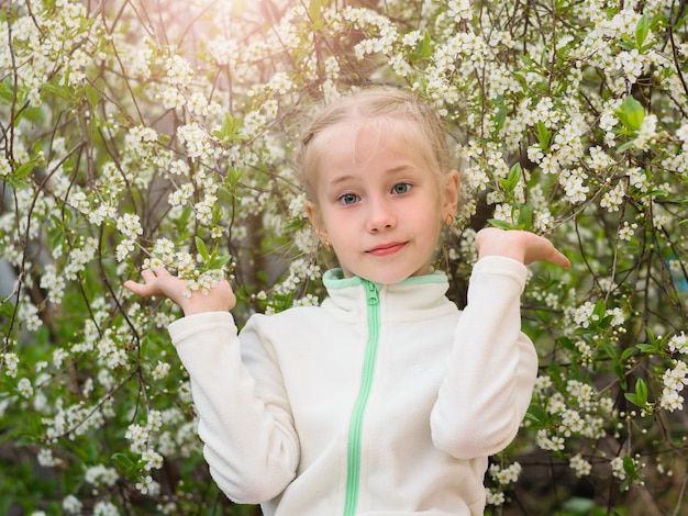 Girl in gym clothes in a flowering cherry blossom tree